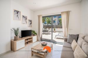 een woonkamer met een bank en een tv bij #194 Dream Flat by Home Holidays in Vale de Pedras