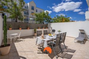 een terras met een tafel en stoelen en een gebouw bij #194 Dream Flat by Home Holidays in Vale de Pedras