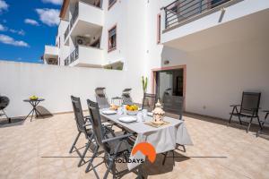 een eetkamer met een tafel en stoelen op een terras bij #194 Dream Flat by Home Holidays in Vale de Pedras