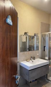 bagno con lavandino e specchio di B&B Ondamarina a Lascari