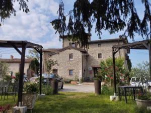an outside view of a stone building with a car parked at Agriturismo Casa Rastelli in Monteorsello