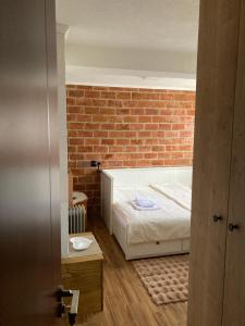 a bedroom with a bed and a brick wall at Apartmani 1490 in Žabljak
