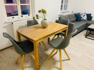 a wooden table and chairs in a living room at Apartment Goldregen in Schwabach