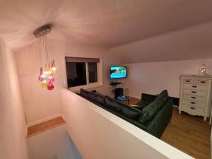a living room with a couch and a television at Mill View Cottage at Pheasant Lane in Ráistín