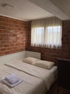 a bed in a room with a brick wall at Apartmani 1490 in Žabljak