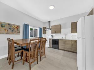 Una cocina con mesa y sillas y un refrigerador. en Parkside Flat #5 - Seacliff Beach Suites, en Leamington