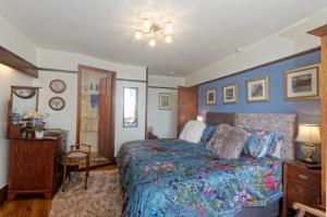 1 dormitorio con cama, mesa y escritorio en Tregondale Manor Farm, en Liskeard
