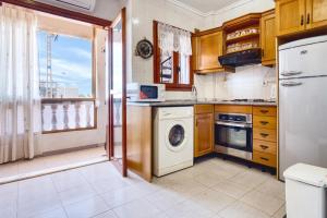 eine Küche mit einer Waschmaschine und einer Waschmaschine in der Unterkunft Rincón de sol y relax in Torrevieja
