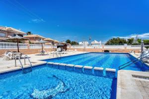 a large swimming pool with blue water at Rincón de sol y relax in Torrevieja