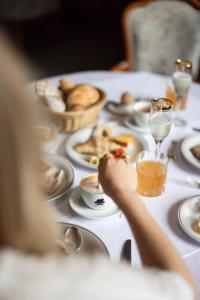 uma pessoa sentada a uma mesa com um prato de comida em Weingarten Terlan - Rooms & Breakfast em Terlano