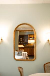 um espelho que reflecte uma sala de estar com um sofá e cadeiras em Weingarten Terlan - Rooms & Breakfast em Terlano