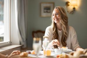 Una donna seduta a tavola che mangia. di Weingarten Terlan - Rooms & Breakfast a Terlano