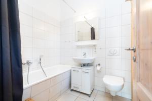 La salle de bains blanche est pourvue d'un lavabo et de toilettes. dans l'établissement Strandpark Sierksdorf H087, à Sierksdorf