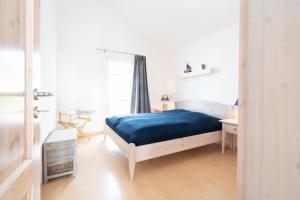 - une chambre avec un lit bleu et une fenêtre dans l'établissement Strandpark Sierksdorf H087, à Sierksdorf