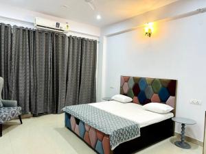 a small bedroom with a bed and a chair at Ajnara 2 in Varanasi