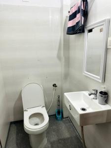 a bathroom with a white toilet and a sink at Ajnara 2 in Varanasi