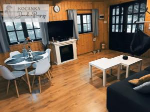 sala de estar con mesa y sofá en Domek w Puszczy ,,Kocanka", en Mężyk