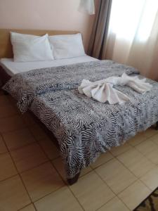 een bed met een zwart-wit dekbed erop bij Hotel Illusions in Kakamega