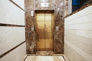 ムンバイにあるKAE Residencyのタイル張りの壁のバスルームのドア