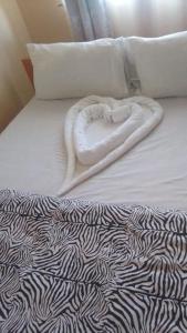 een bed met een deken in de vorm van een hart bij Hotel Illusions in Kakamega
