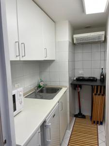 una cucina con armadi bianchi e lavandino di Living Genova Apartment a Genova