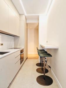 a kitchen with white cabinets and a black stool at xGP Track Flat, Up to 14 Guests in Monte Carlo