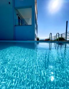 una piscina de agua azul frente a un edificio en Sun Angelo luxury apartment in Paradise 2, en Arménoi