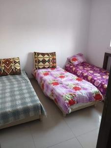 El Ahmarにあるإقامة طلالのツインベッド2台とソファが備わる客室です。