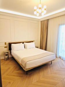 a bedroom with a large bed with a chandelier at xGP Track Flat, Up to 14 Guests in Monte Carlo
