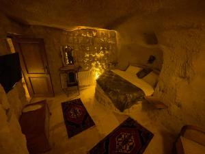 sypialnia z łóżkiem w kamiennym pokoju w obiekcie Lubberona Cave Cappadocia w mieście Nar