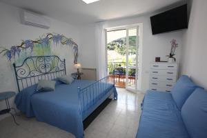 a bedroom with a blue bed and a couch at Jungle Rooms in Cetara