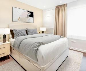 biała sypialnia z dużym łóżkiem i oknem w obiekcie Beautiful Apartment by Piccadilly Circus w mieście Edmonton