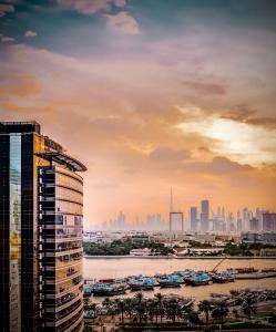 Golden Sands Boutique Hotel-Dubai Creek في دبي: إطلالة على أفق المدينة مع مبنى طويل