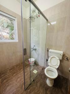 プネにあるElite Stays Viman nagarのバスルーム(トイレ、ガラス張りのシャワー付)