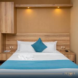 een slaapkamer met een bed met blauwe en witte kussens bij PEROLA HOTEl in Maputo