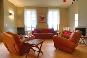 ein Wohnzimmer mit 2 Stühlen und einem Sofa in der Unterkunft Le Chalet Saint Vincent in Seurre