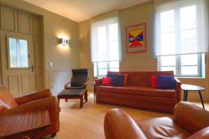 ein Wohnzimmer mit einem Sofa und 2 Stühlen in der Unterkunft Le Chalet Saint Vincent in Seurre