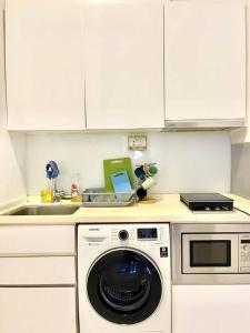 een keuken met een wasmachine en een wastafel bij Centralize Stylish Loft Apartment Beside Mrt 摩登小屋 in Singapore