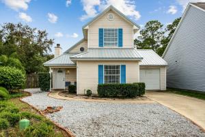 a white house with blue windows and a driveway at 3192 Birdseye Cir in Gulf Breeze