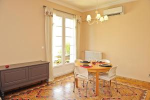 d'une salle à manger avec une table, des chaises et une fenêtre. dans l'établissement Appartement Les Hortensias, à Avignon