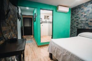 een kamer met een bed en een groene muur bij Hotel Villas Tiburon in Holbox Island