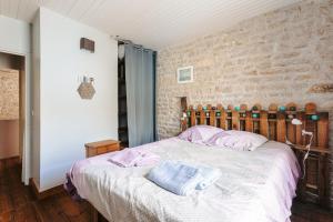 a bedroom with a bed and a brick wall at Maison de vacances hyper centre in Sainte-Marie-de-Ré