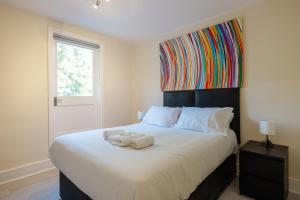 ein Schlafzimmer mit einem großen Bett mit zwei Handtüchern darauf in der Unterkunft 4 bedroom Stunning Flat Near Westfield & Trains in London