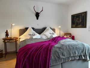 a bedroom with a bed with a purple blanket on it at Weingut Bastian in Brauneberg