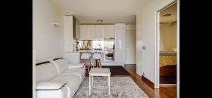 sala de estar con sofá blanco y cocina en Beach & airport appartement, en Saint-Laurent-du-Var