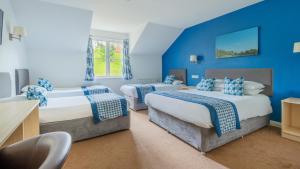 2 camas en una habitación con paredes azules en Wookey Hole Hotel, en Wells