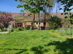 an old house with a grass yard in front of it at Le Calibrochet - 24 Heures du Mans in Saint-Ouen-en-Belin