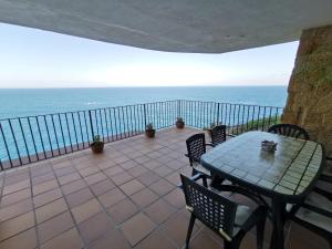 a table and chairs on a balcony with the ocean at Cap Sa Sal - Apartamento Vistamar in Begur
