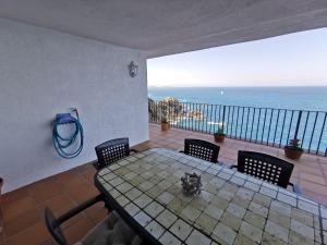 a table and chairs in a room with a view of the ocean at Cap Sa Sal - Apartamento Vistamar in Begur