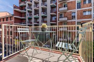 a table and chairs on a balcony with a building at [20 minuti dal Duomo] Milano Smart Apartment in Sesto San Giovanni
